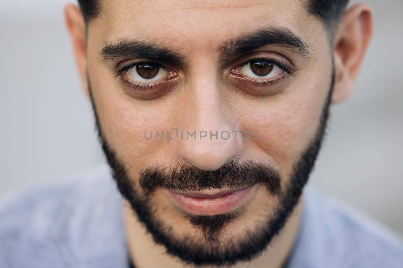 Face of bearded caucasian armenian young man looking at camera. Attractive guy stand on street city lifestyle. People. Beauty. Stand outdoors.