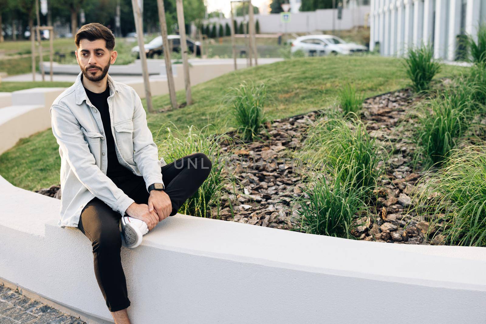 Gorgeous young bearded mixed-race elegant man with brown eyes looking stright outdoors. Outdoor relax. Happy relax. Male portraits