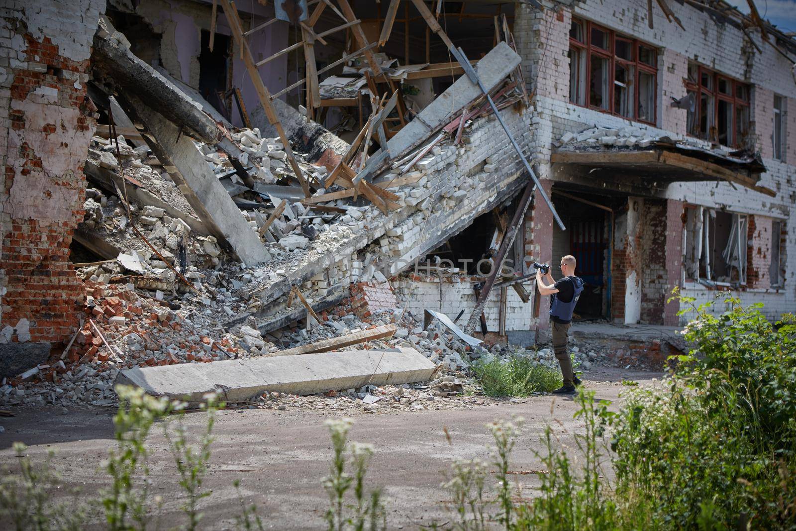 War correspondent photographs destroyed buildings after the bombing by sarymsakov