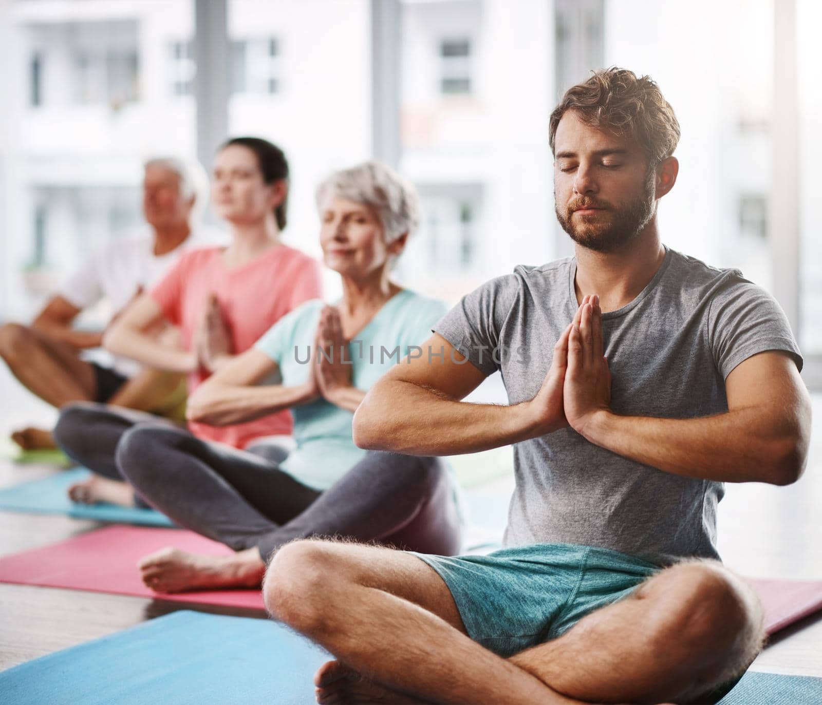 a group of people meditating while practicing yoga.