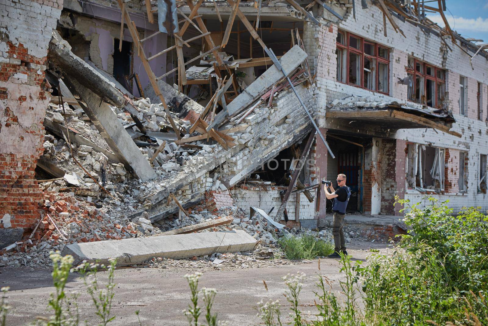 War correspondent photographs destroyed buildings after the bombing by sarymsakov