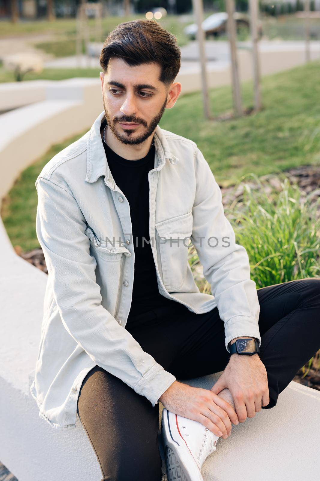 Gorgeous face of young bearded mixed-race elegant man with brown eyes. Beautiful caucasian european man looking stright outdoors. Outdoor relax. Happy relax. Male portraits. by uflypro