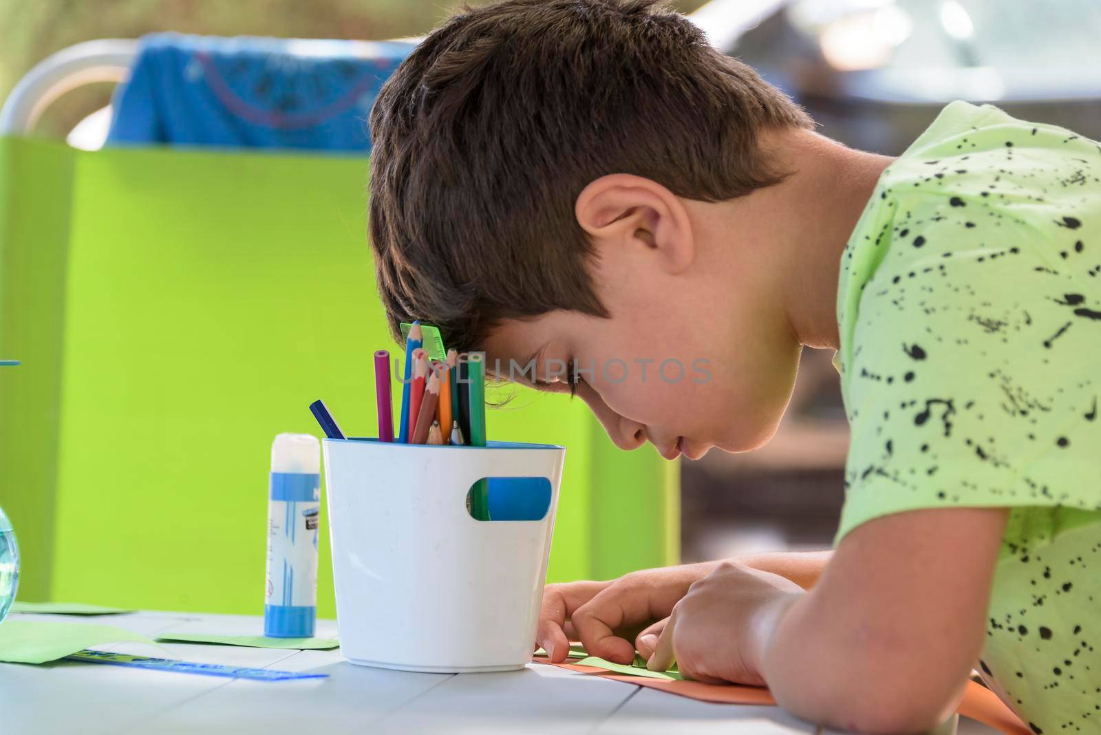 Primary school boy doing manual work while on vacation and preparing to go back to school