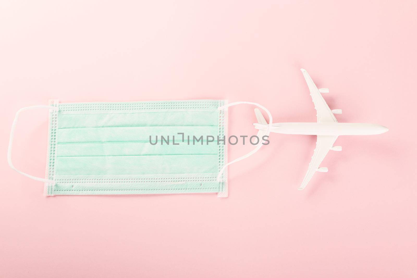 World Tourism Day, Top view model plane and medical face mask, Holiday accessory beach trip travel vacation studio shot isolated pink background with copy space