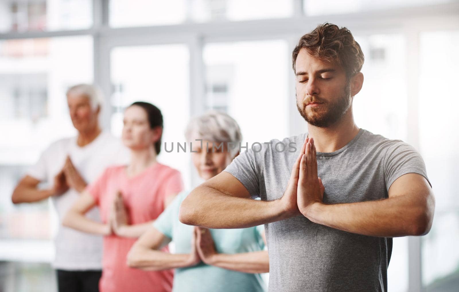 a group of people meditating while practicing yoga.