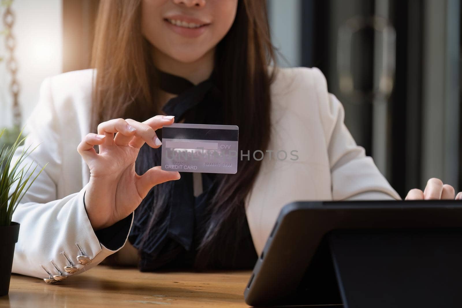 Asian young woman using a tablet and credit card for online shopping.