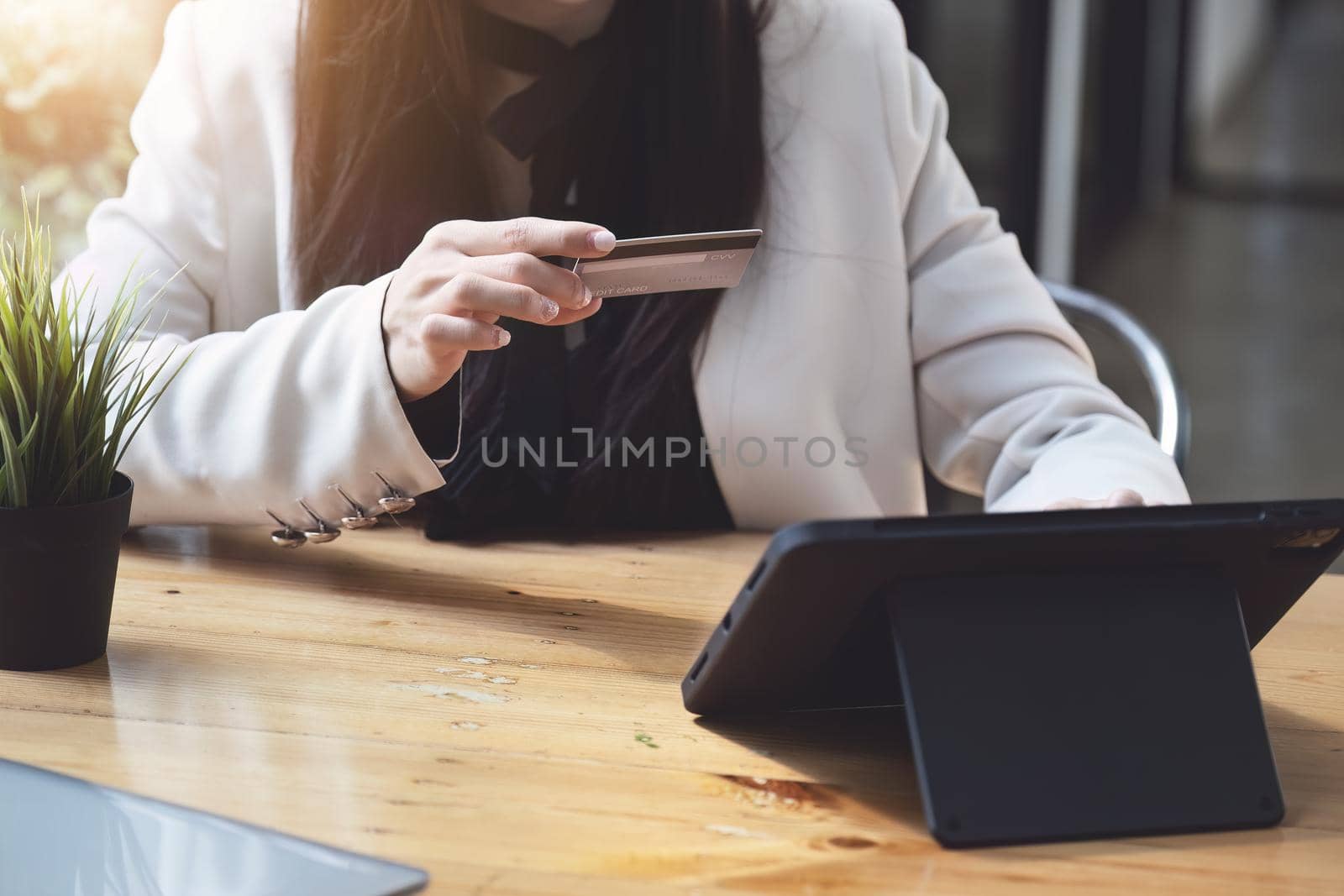 Asian young woman using a tablet and credit card for online shopping by Manastrong