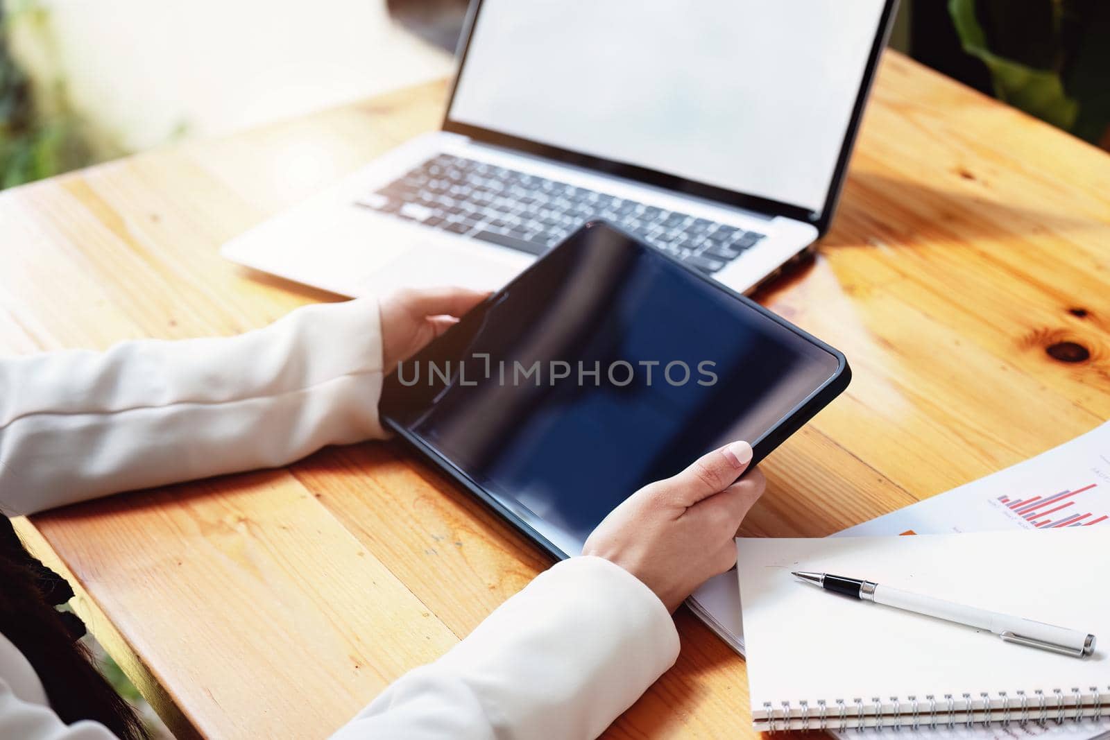 business woman using a tablet computer for data analysis, marketing, accounting by Manastrong