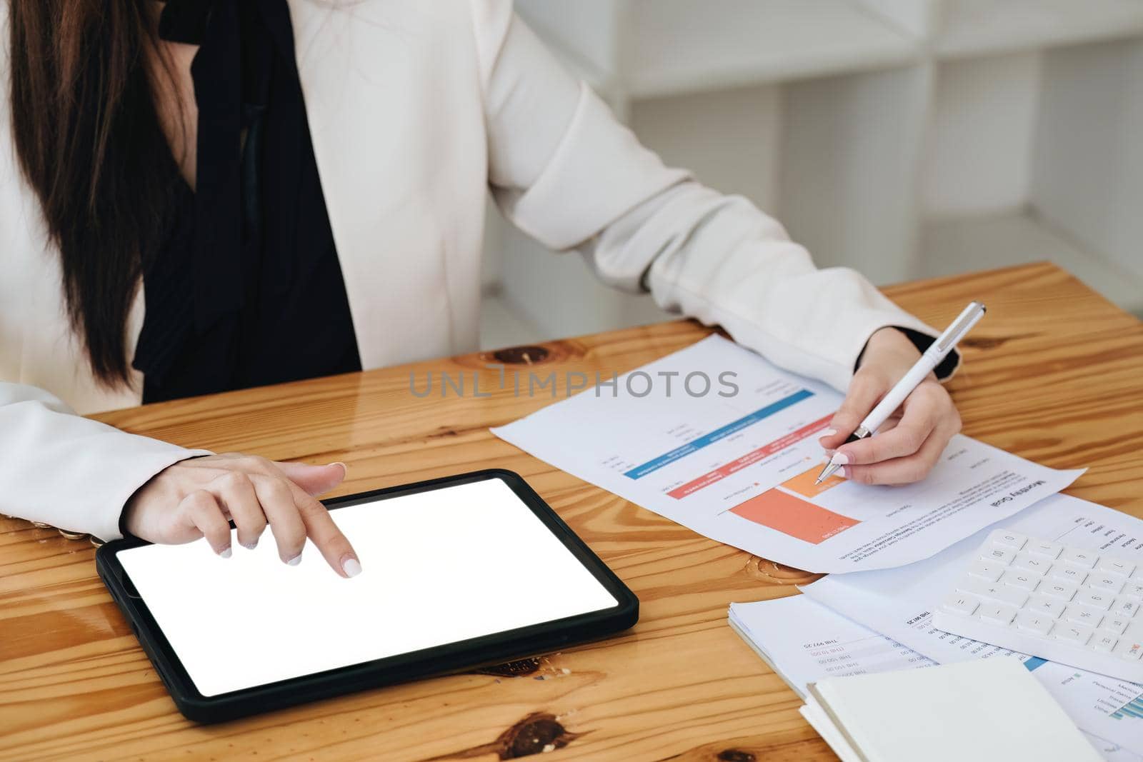 business woman using a tablet computer for data analysis, marketing, accounting by Manastrong