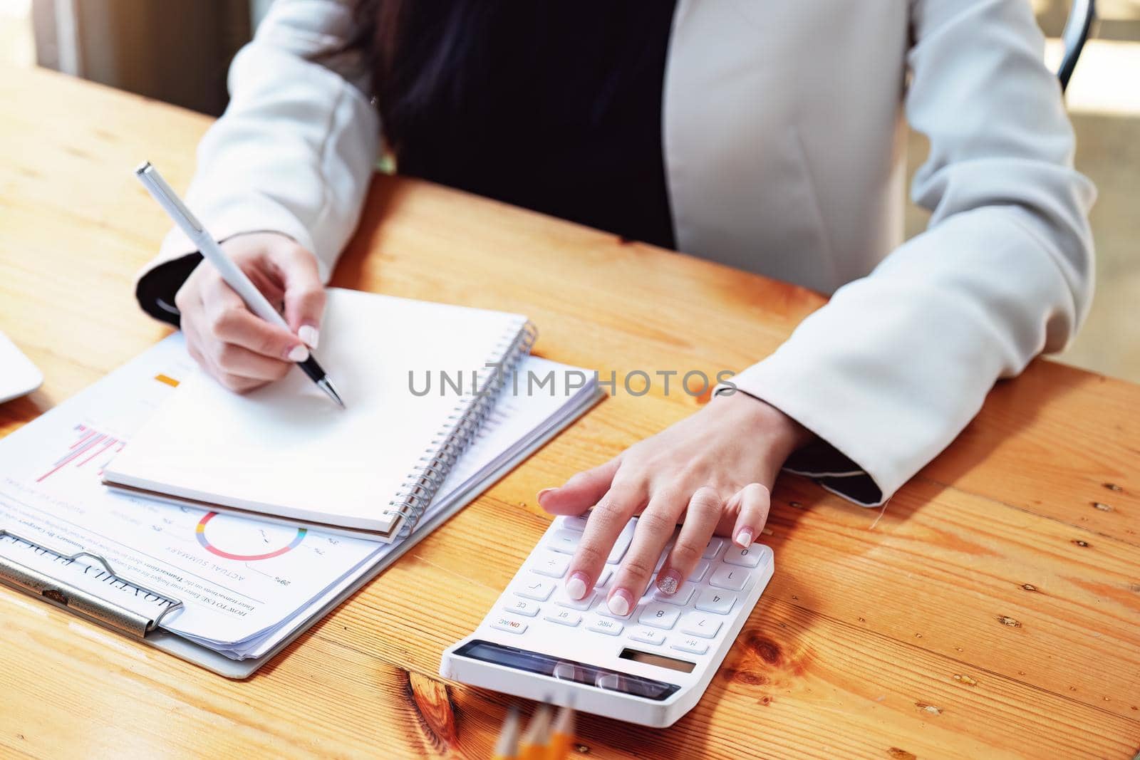 financial, Planning, Marketing and Accounting, Asian woman Economist using calculator to calculate investment documents.