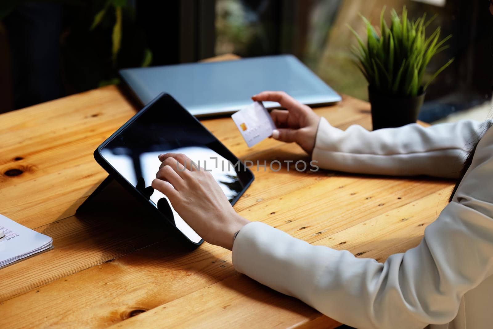 Asian young woman using a tablet and credit card for online shopping.