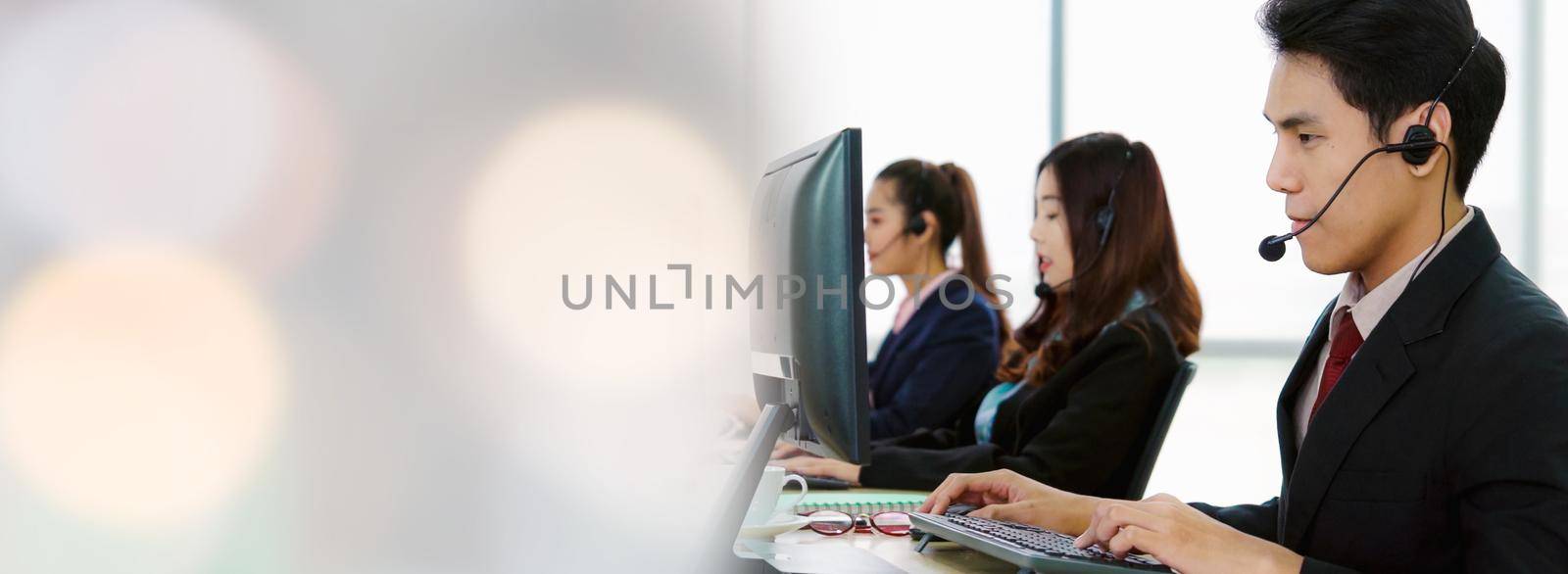 Business people wearing headset working in office in widen view to support remote customer or colleague. Call center, telemarketing, customer support agent provide service on telephone video call.