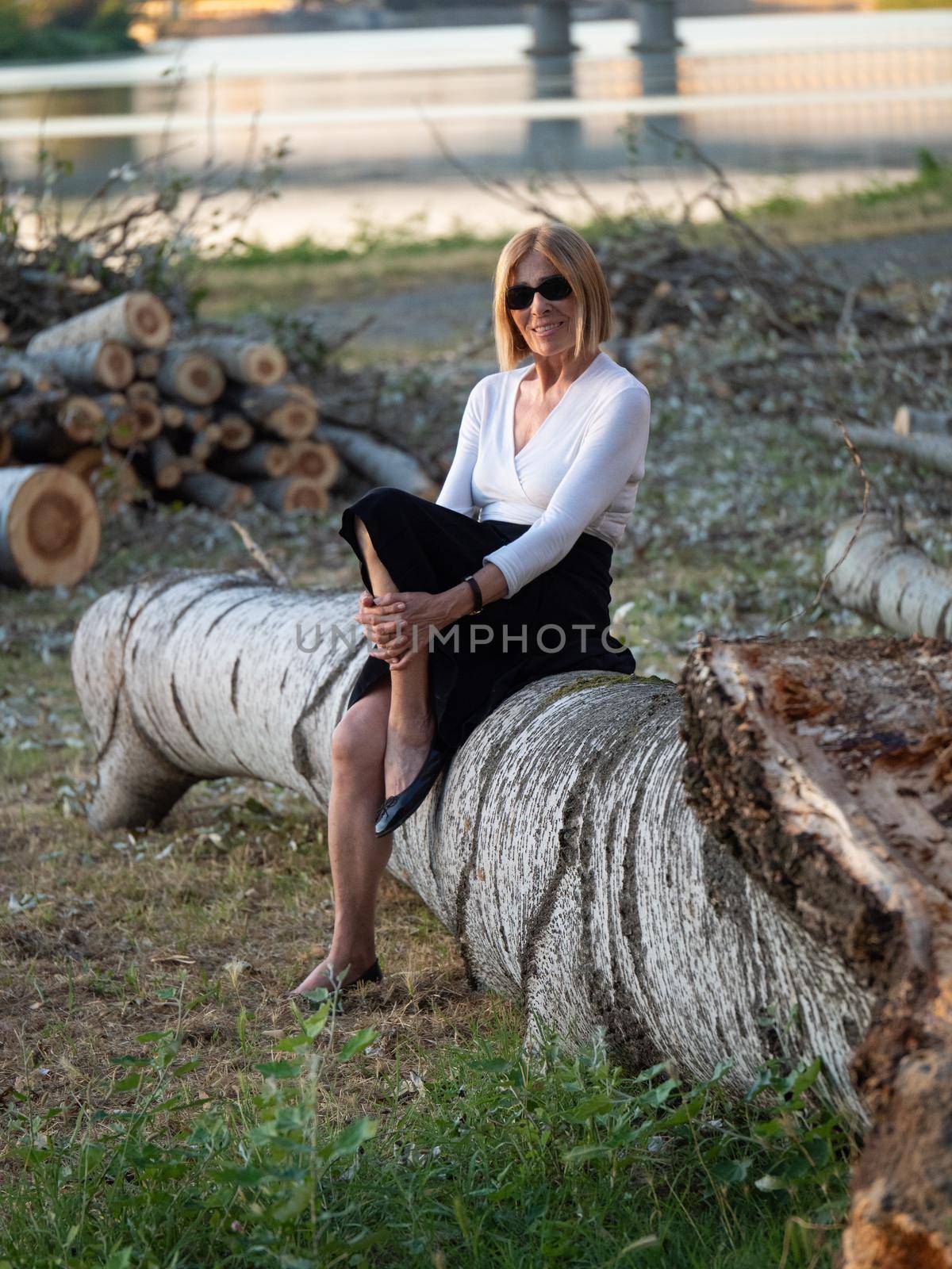 senior fit elegant lady dressed blaka dn white wearing sunglasses enjoying nature in summer