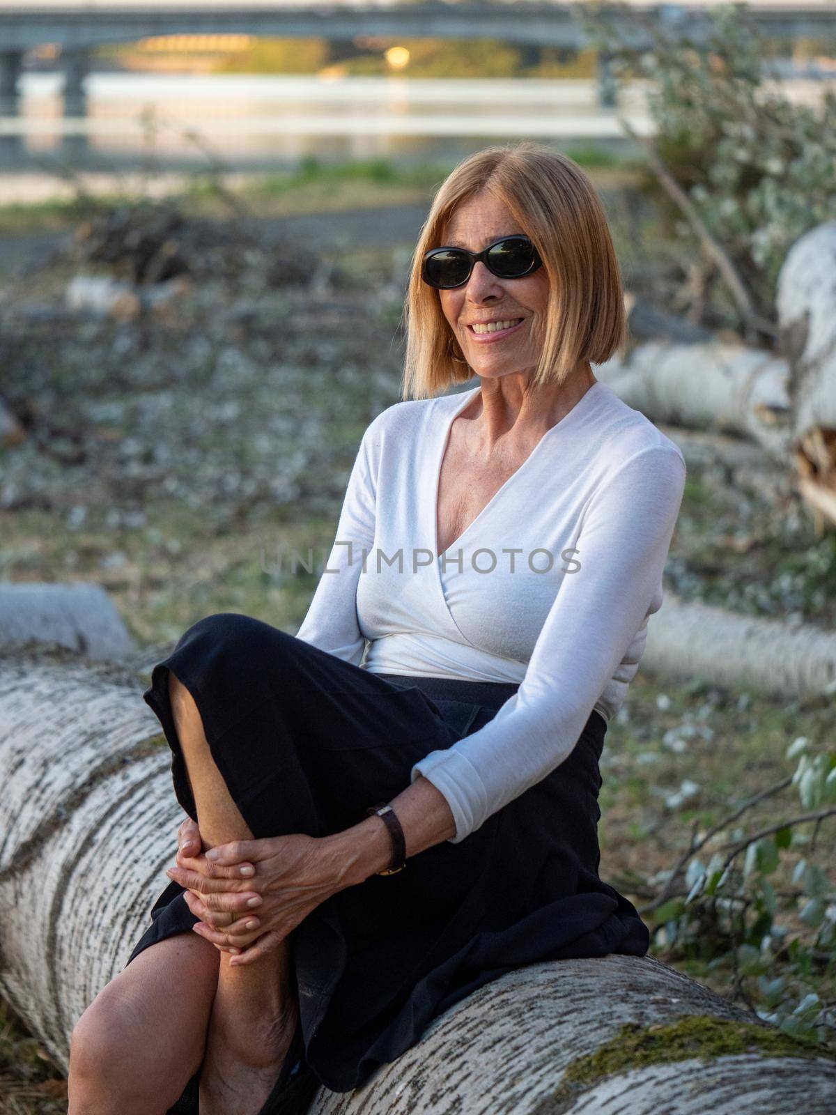 senior fit elegant lady dressed blaka dn white wearing sunglasses enjoying nature in summer