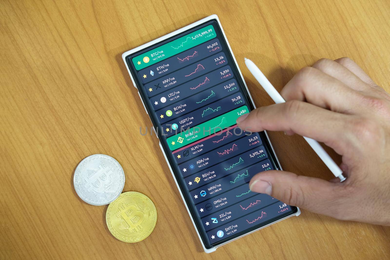 Investors are using a mobile phone to open a currency trading program cryptocurrencies by Manastrong