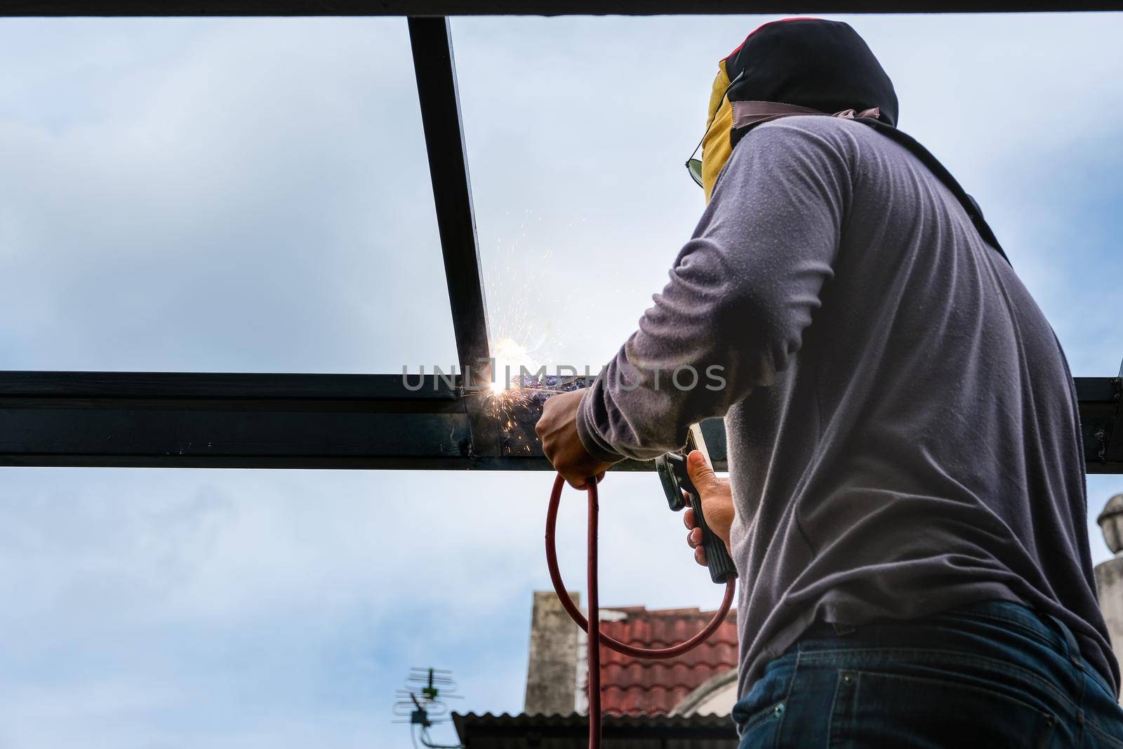 The welder is welding the steel structure to add to the house.