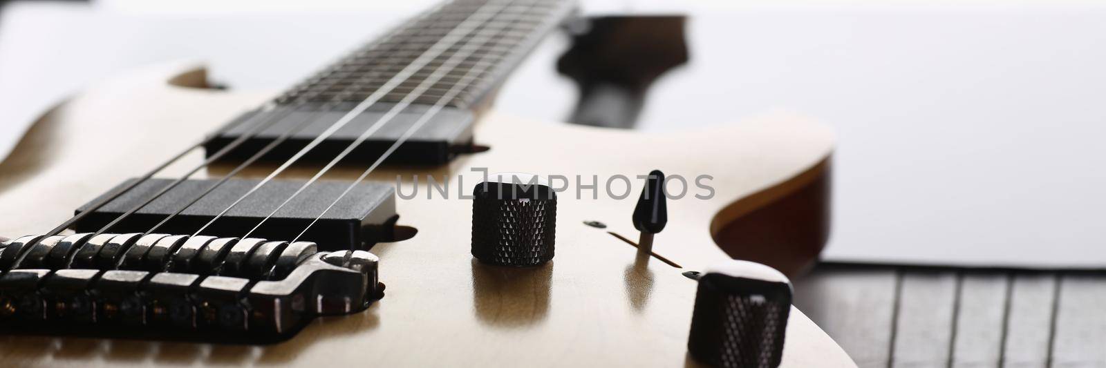 Close-up of classic shape wooden electric guitar with rosewood neck. Six stringed learning lesson musician instrument, education, hobby, leisure concept