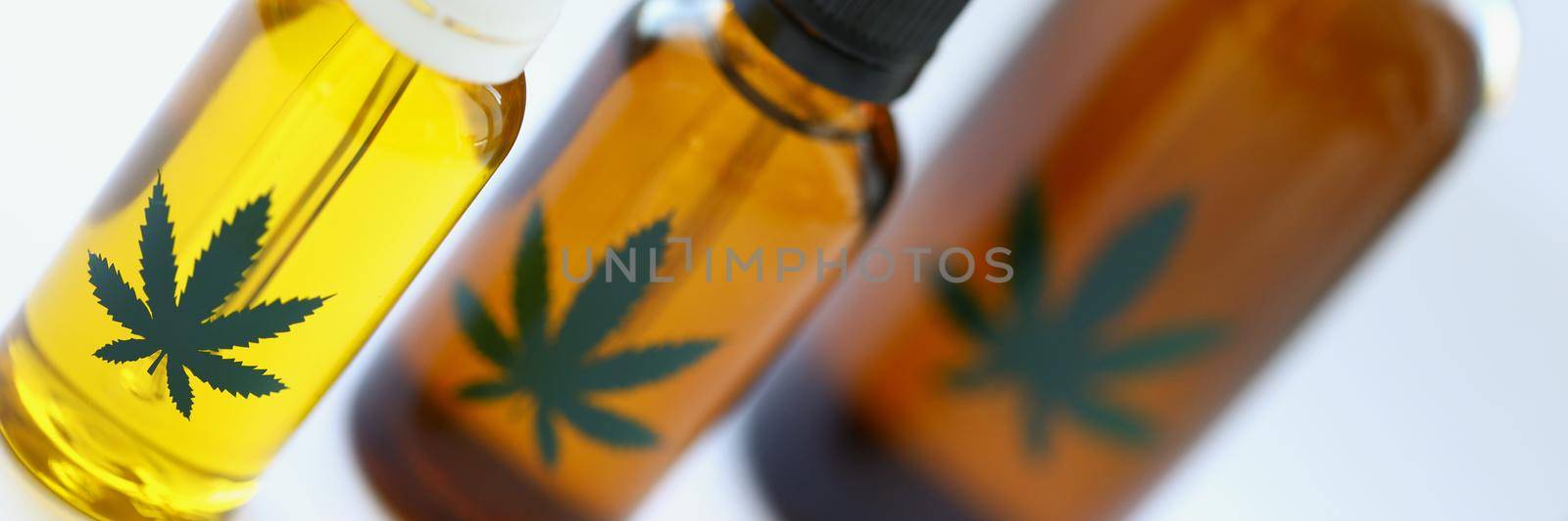 Close-up of set of marijuana extract oil and spray in plastic bottles. Medication for home treatment in jars. Alternative medicine, health, hemp concept