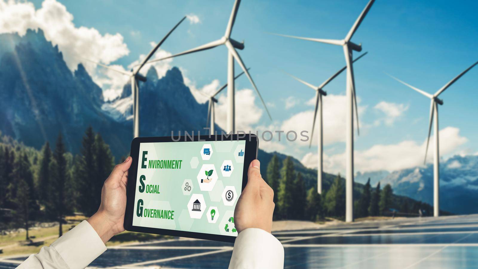 Green business transformation for environment saving and ESG business concept. Businessman using tablet to set corporate goal toward environmental friendly management and alternative clean energy use.