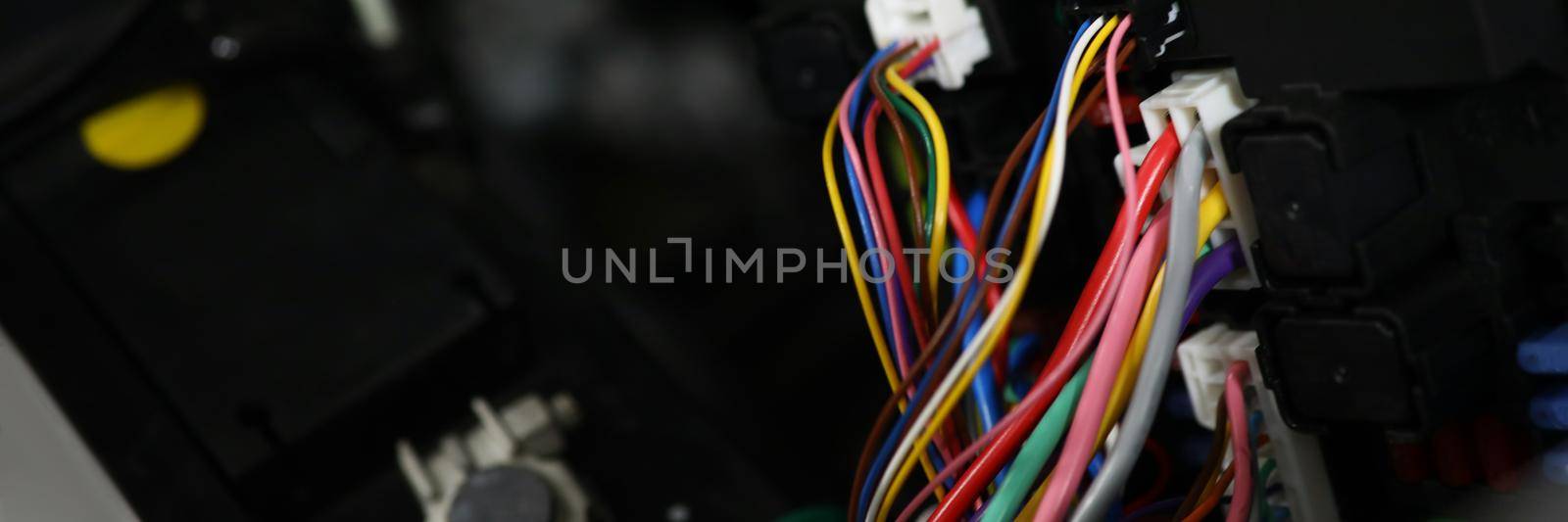 Close-up of set of cables with multicolored wires and connectors in car. Electric connector plug put in car engine. Maintenance for automobile, fix concept