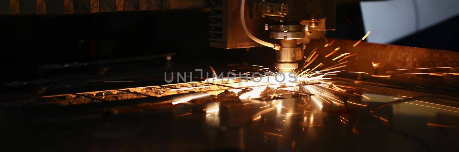 Cutting machine in work and metal plate, sparks fly of machine head by kuprevich