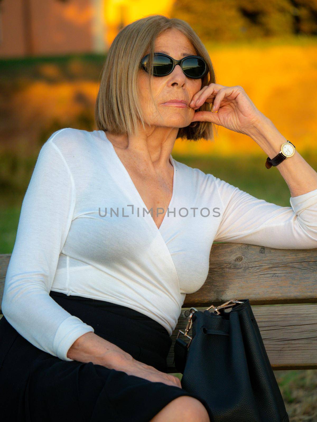 senior fit elegant lady dressed blaka dn white wearing sunglasses enjoying nature in summer