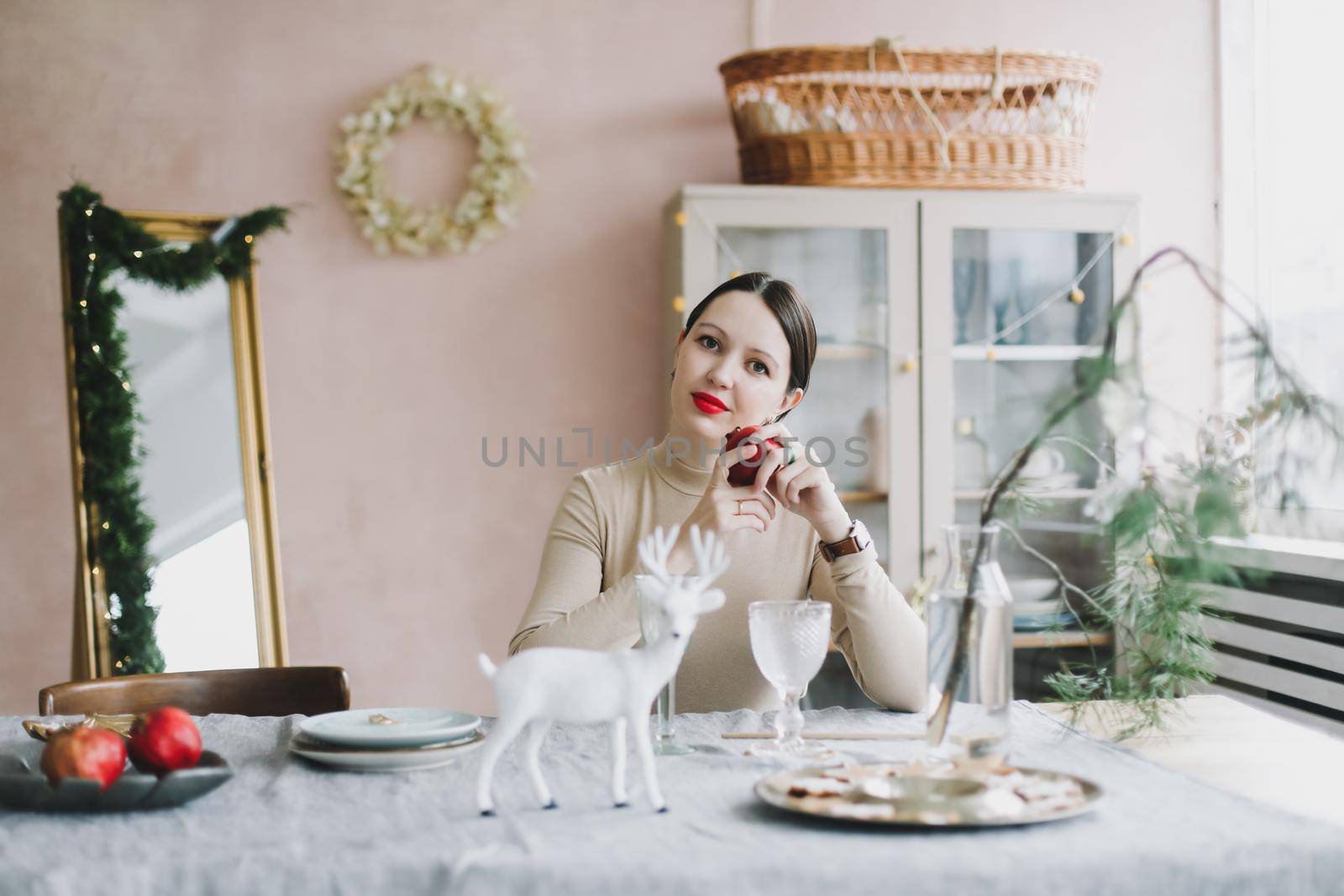 Woman portrait on the background of a Christmas tree in a home interior and festive atmosphere.