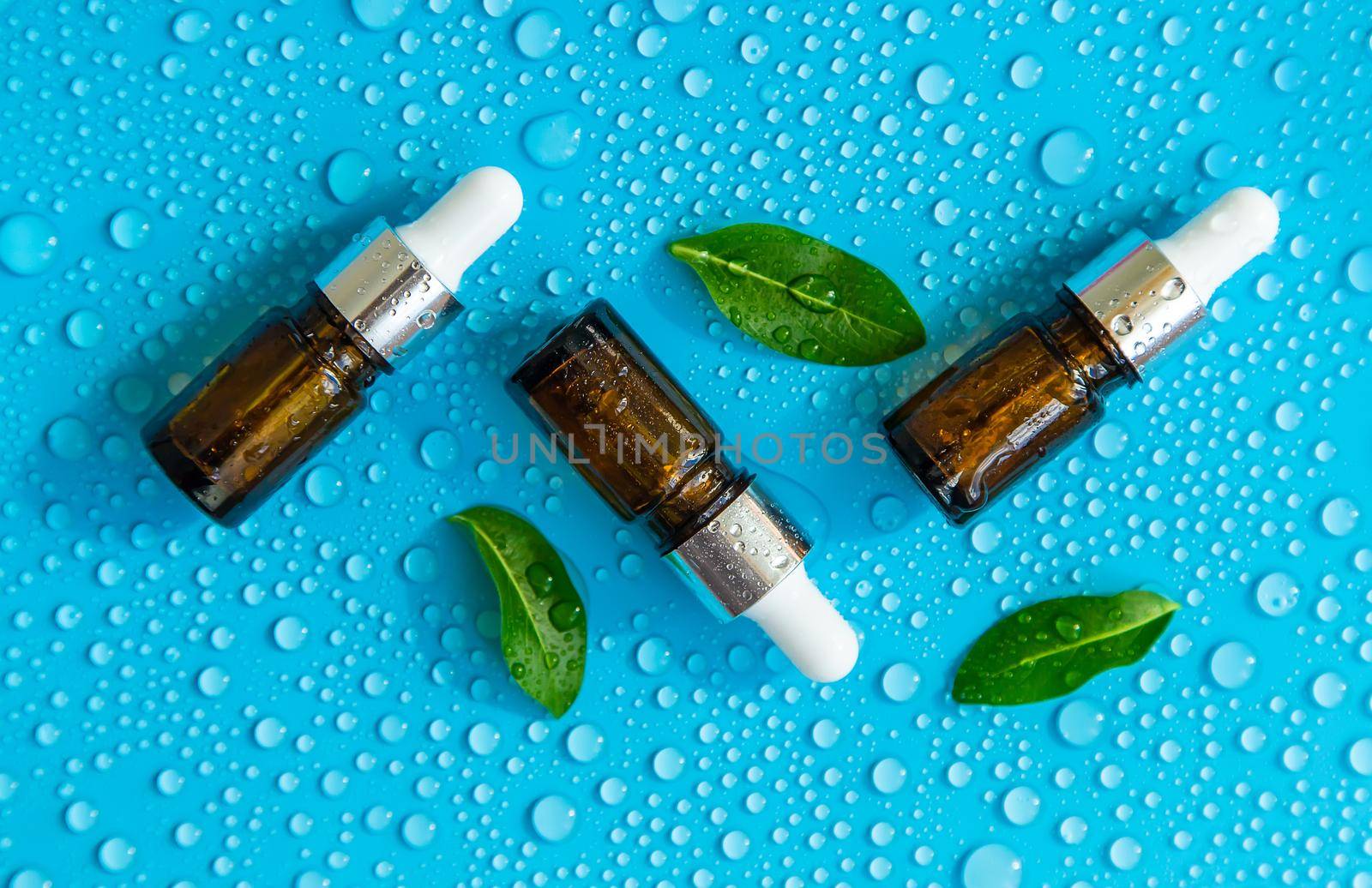 Bottle of cosmetics and drops of liquid, moisturizing. Hyaluronic acid. Selective focus. Spa.