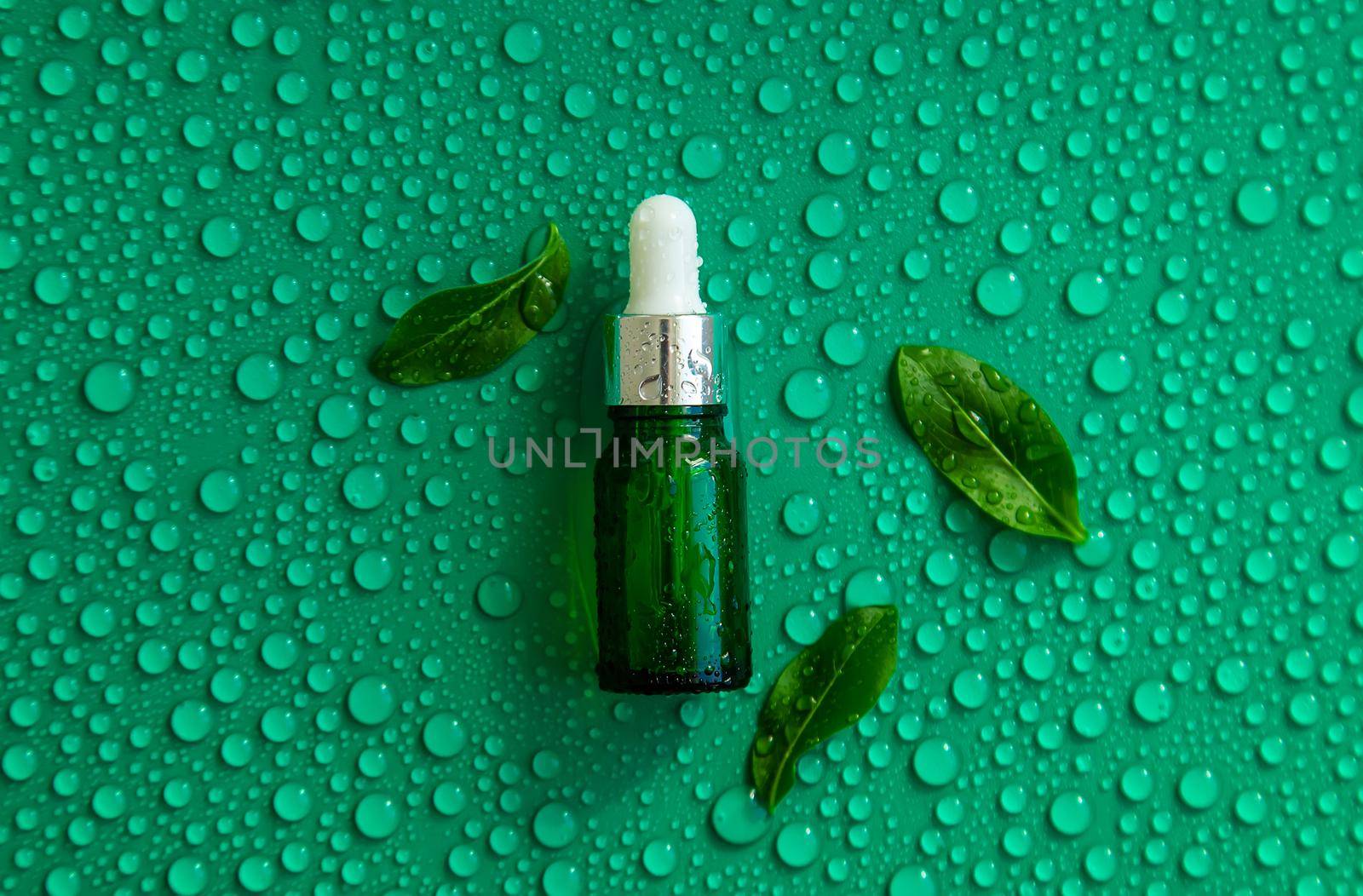 Bottle of cosmetics and drops of liquid, moisturizing. Hyaluronic acid. Selective focus. by yanadjana