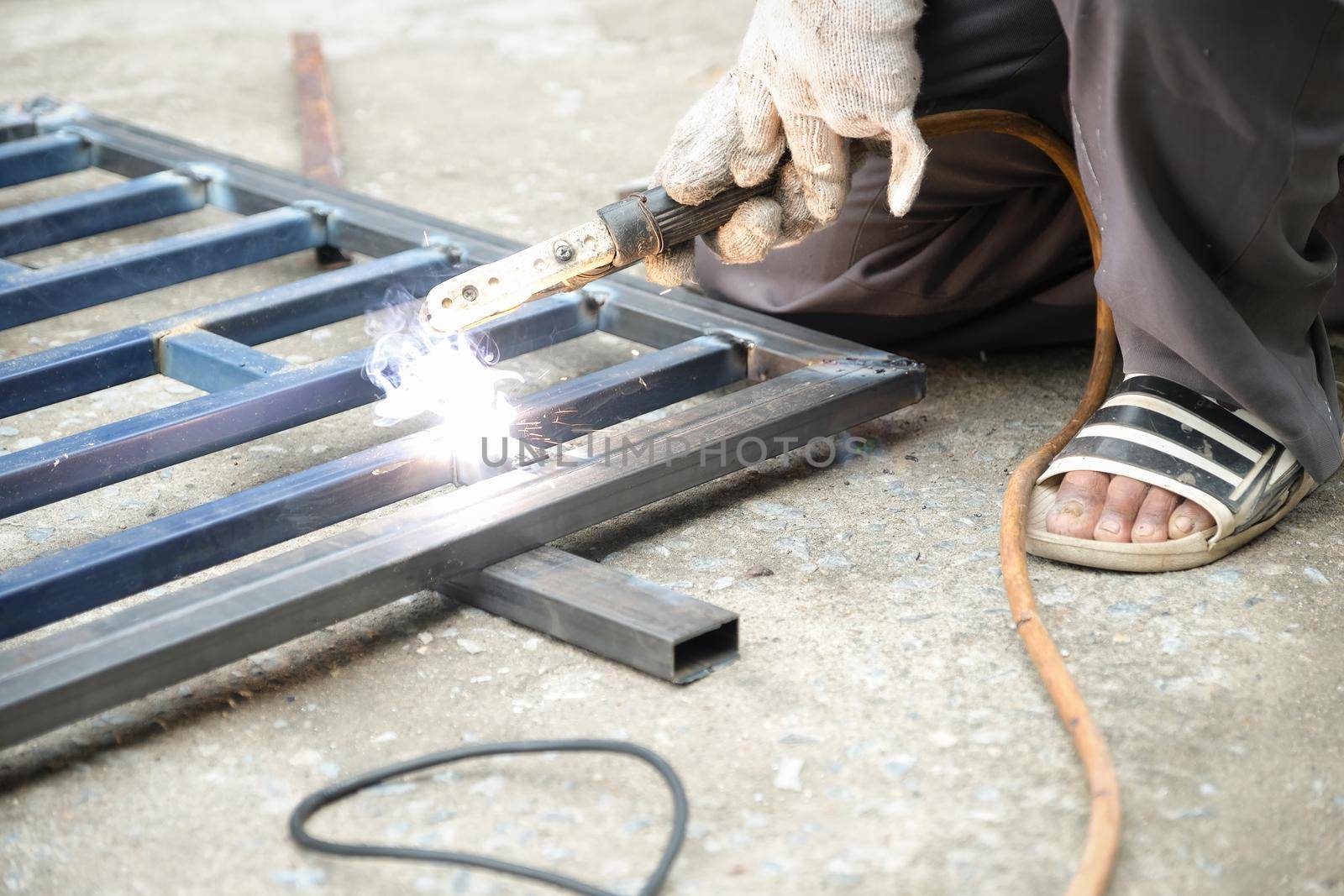 The welder is welding the steel structure to add to the house.