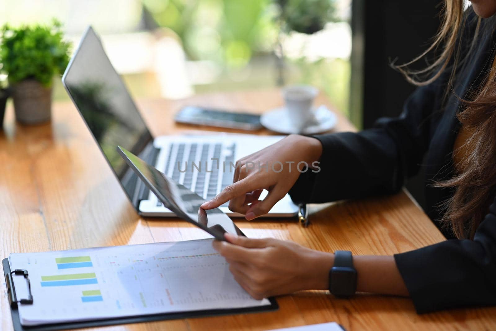 Businesswoman working with digital tablet and laptop computer in modern office.