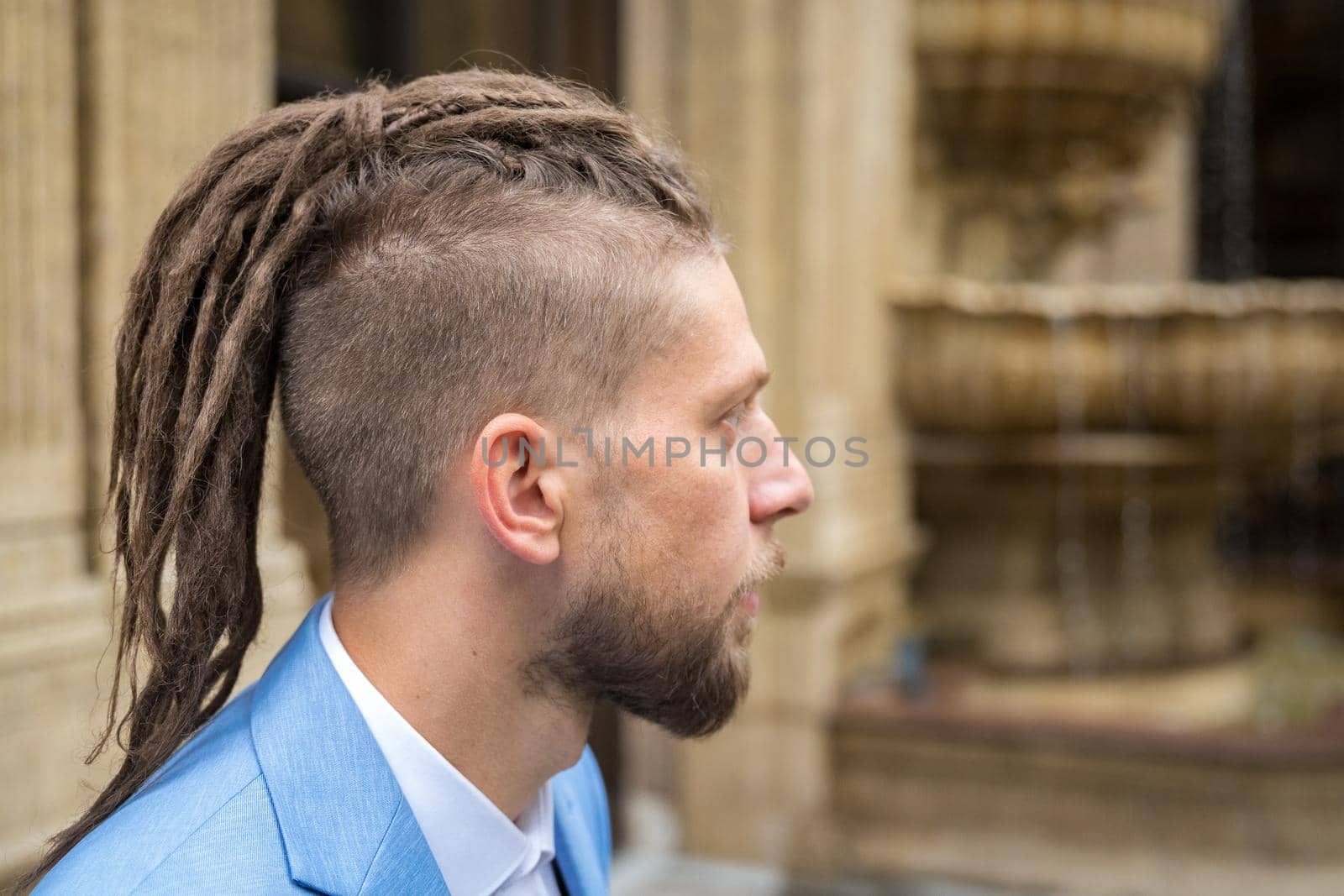 Portrait in profile of a hipster caucasian man with dreadlocks.