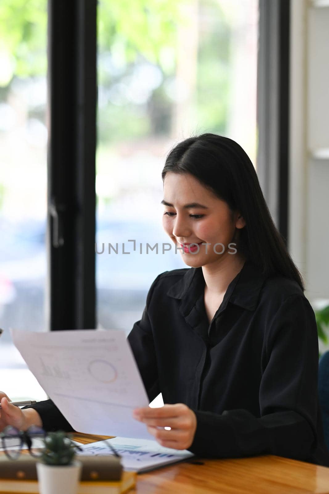 Portrait smiling businesswoman working in bright office. by prathanchorruangsak