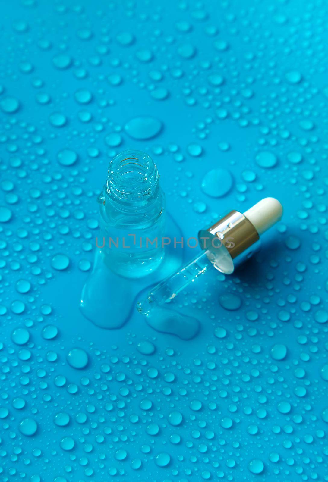 Bottle of cosmetics and drops of liquid, moisturizing. Hyaluronic acid. Selective focus. Spa.