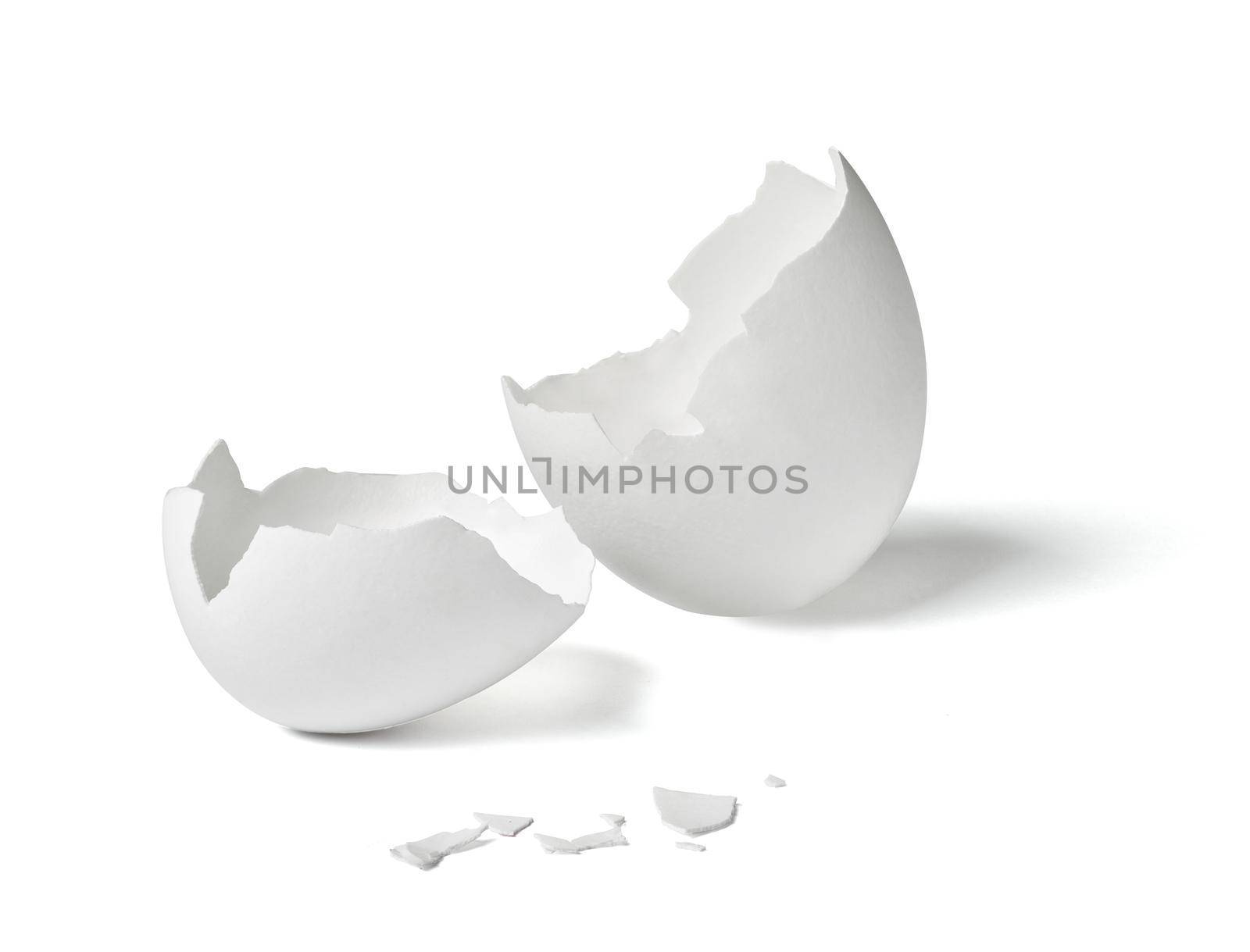 Close up of a broken white eggshell on white background