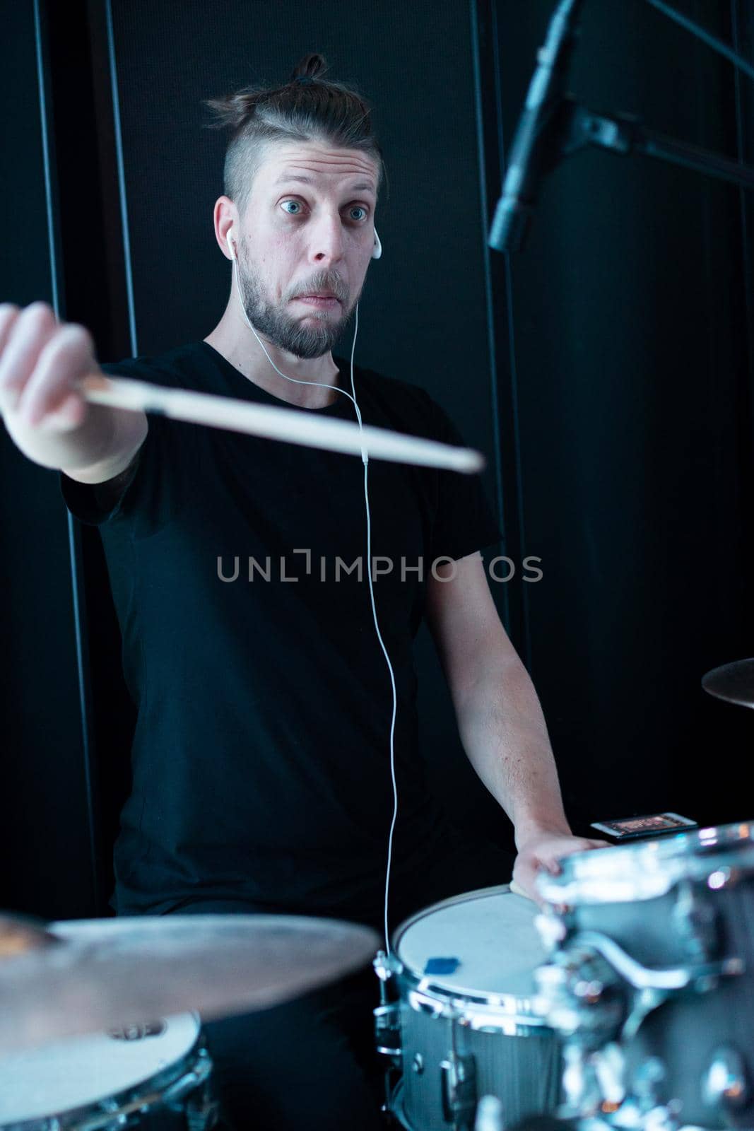 Young emotional funny drummer playing drum kit.