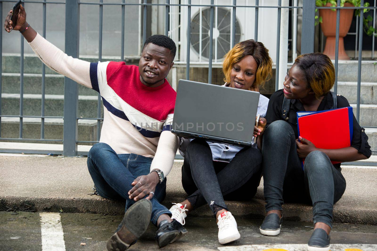 Group of attractive smiling young students dressed casual using laptop by vystek