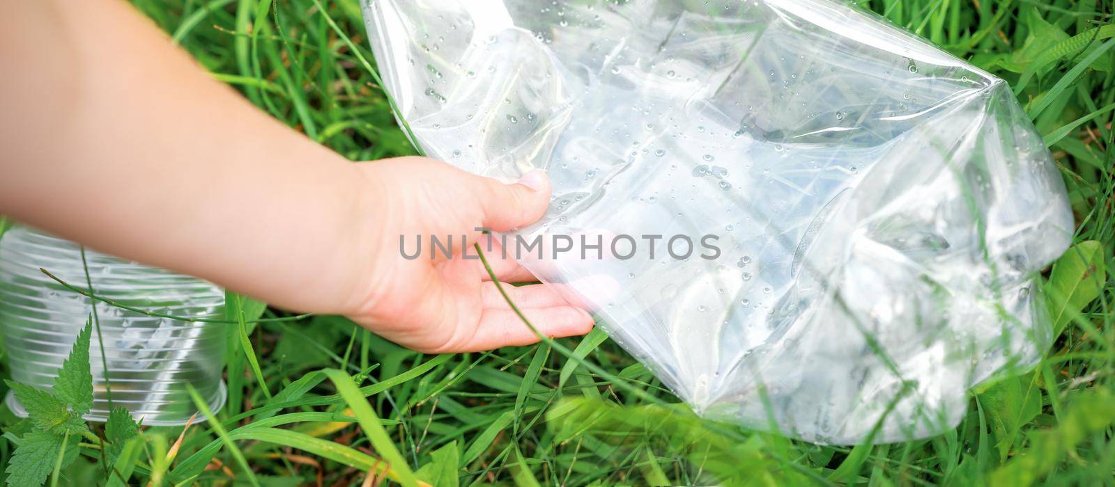 Used empty plastic bag in hands of a little girl while cleaning the park from debris