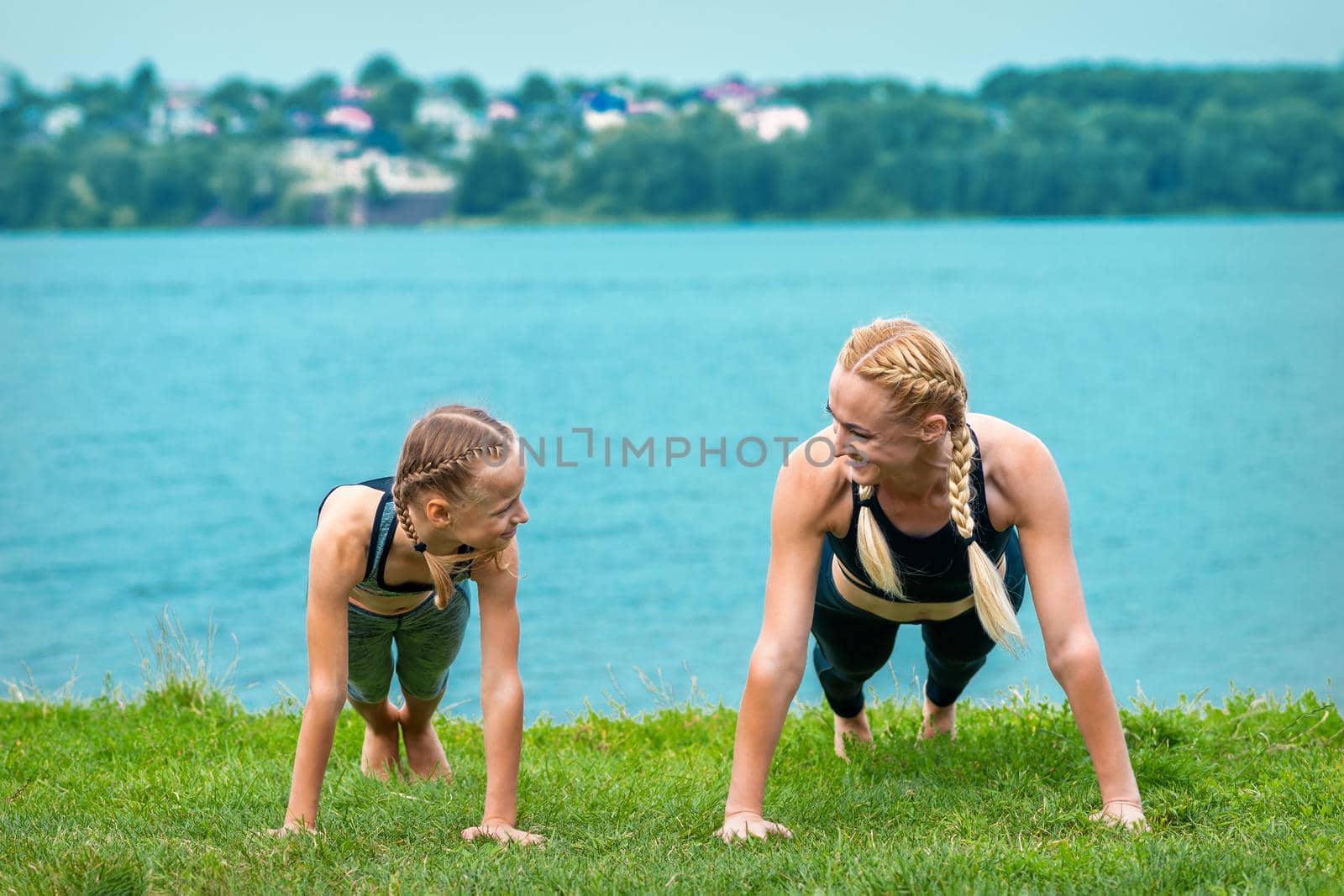 Woman and girl doing push-up exercise by okskukuruza