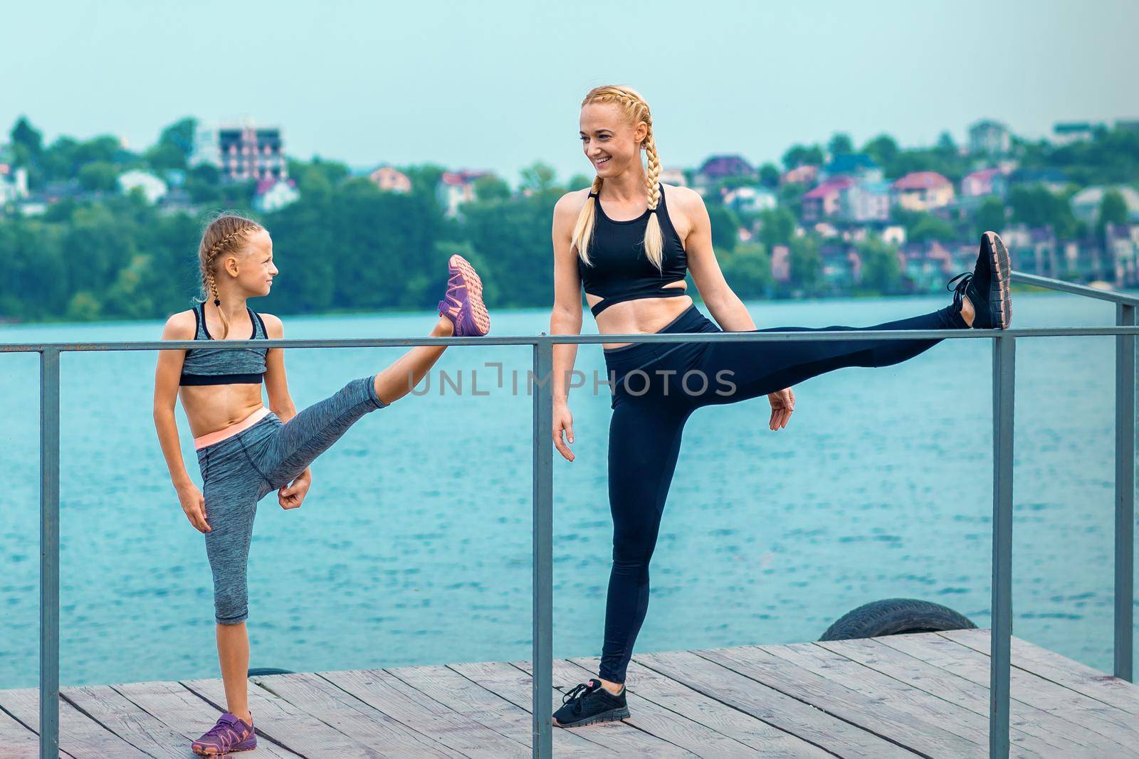 Woman and child are doing sport exercises by okskukuruza