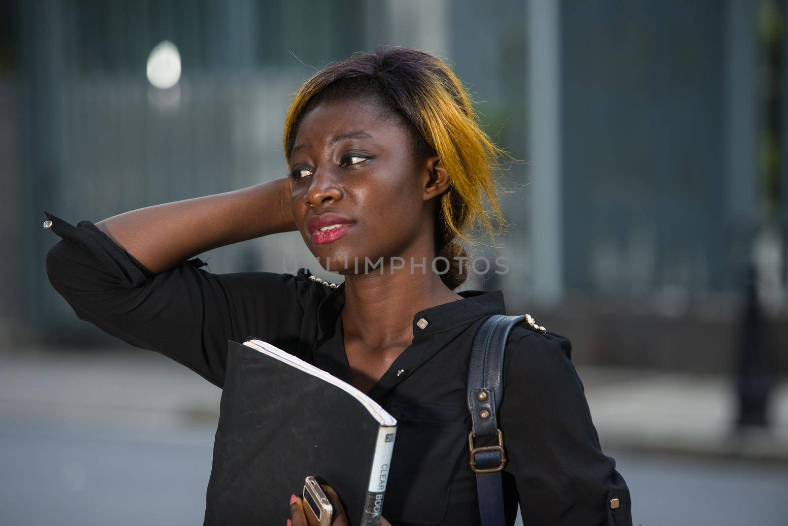 young student standing in black shirt on the street thinking.