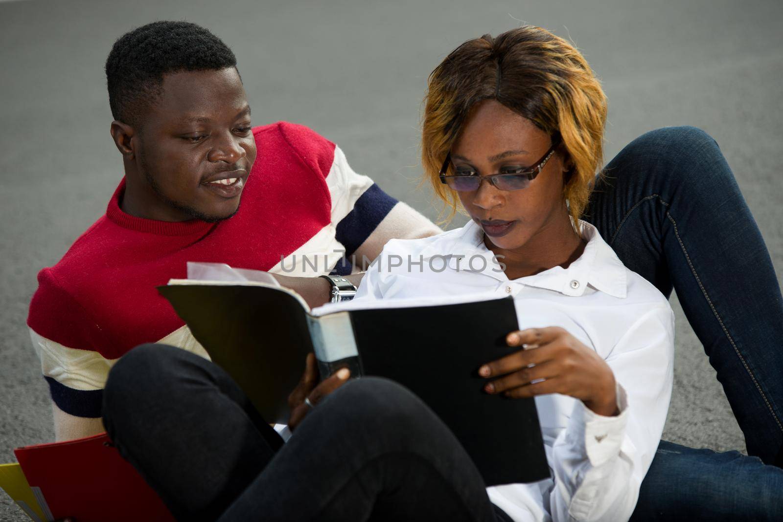 young students embracing to look at notebook smiling.