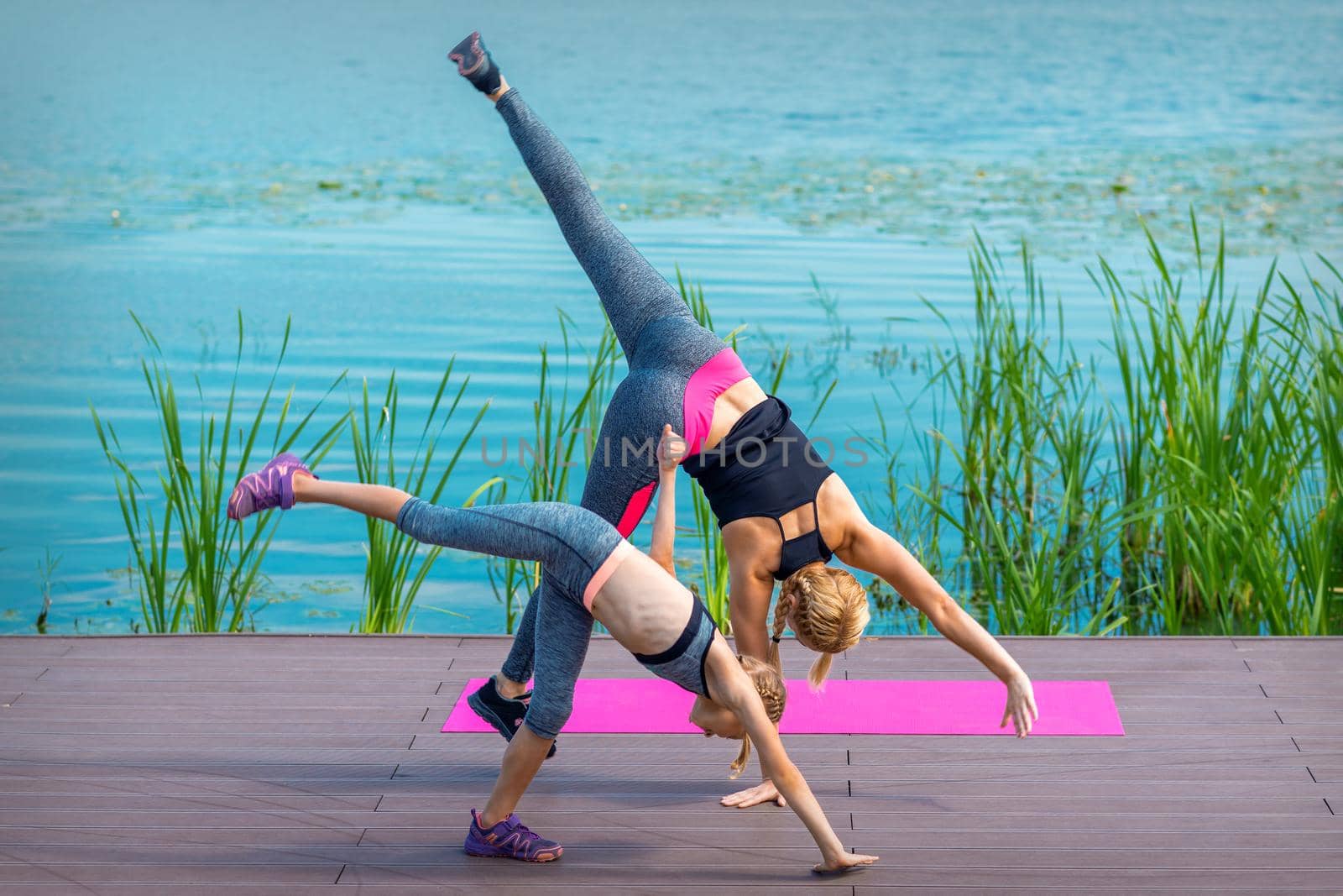 Woman and child doing handstand exercise by okskukuruza