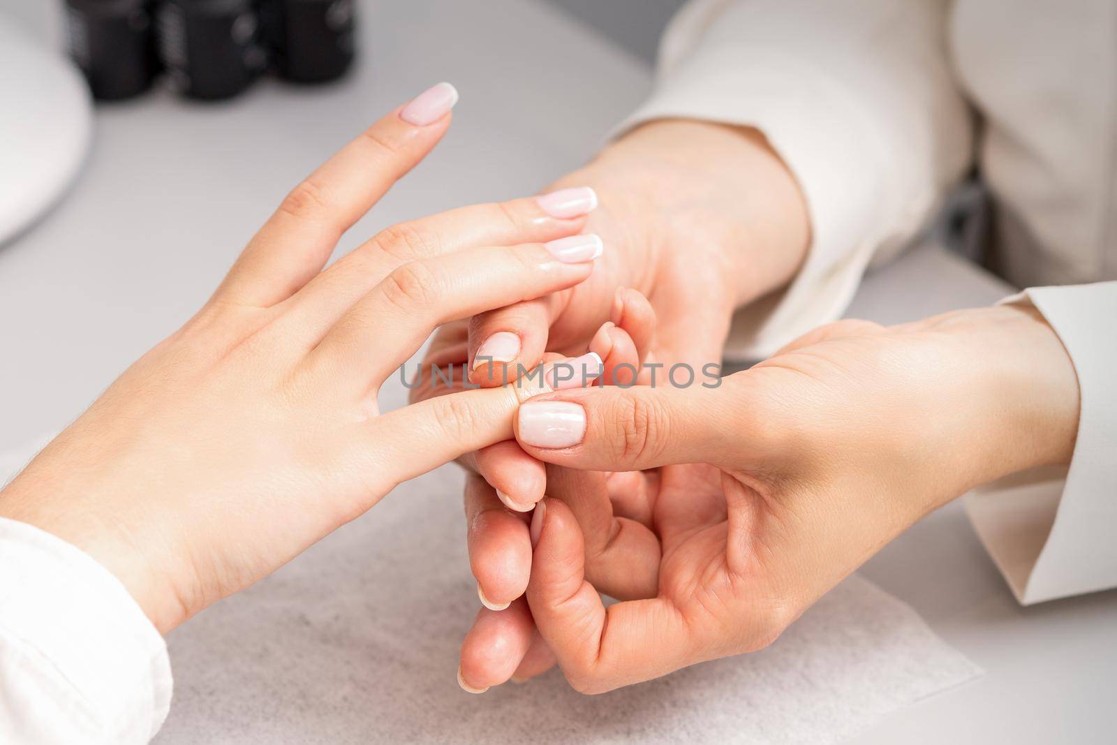 A woman's hand getting a finger massage in a nail salon. Manicure treatment at beauty spa