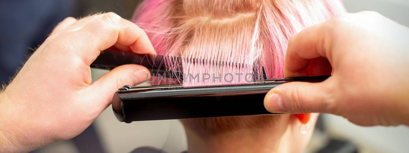Hairdresser straightening short pink hair by okskukuruza