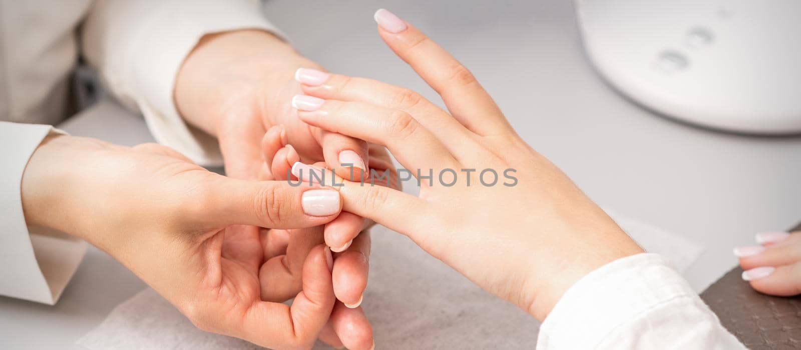 A woman's hand getting a finger massage in a nail salon. Manicure treatment at beauty spa