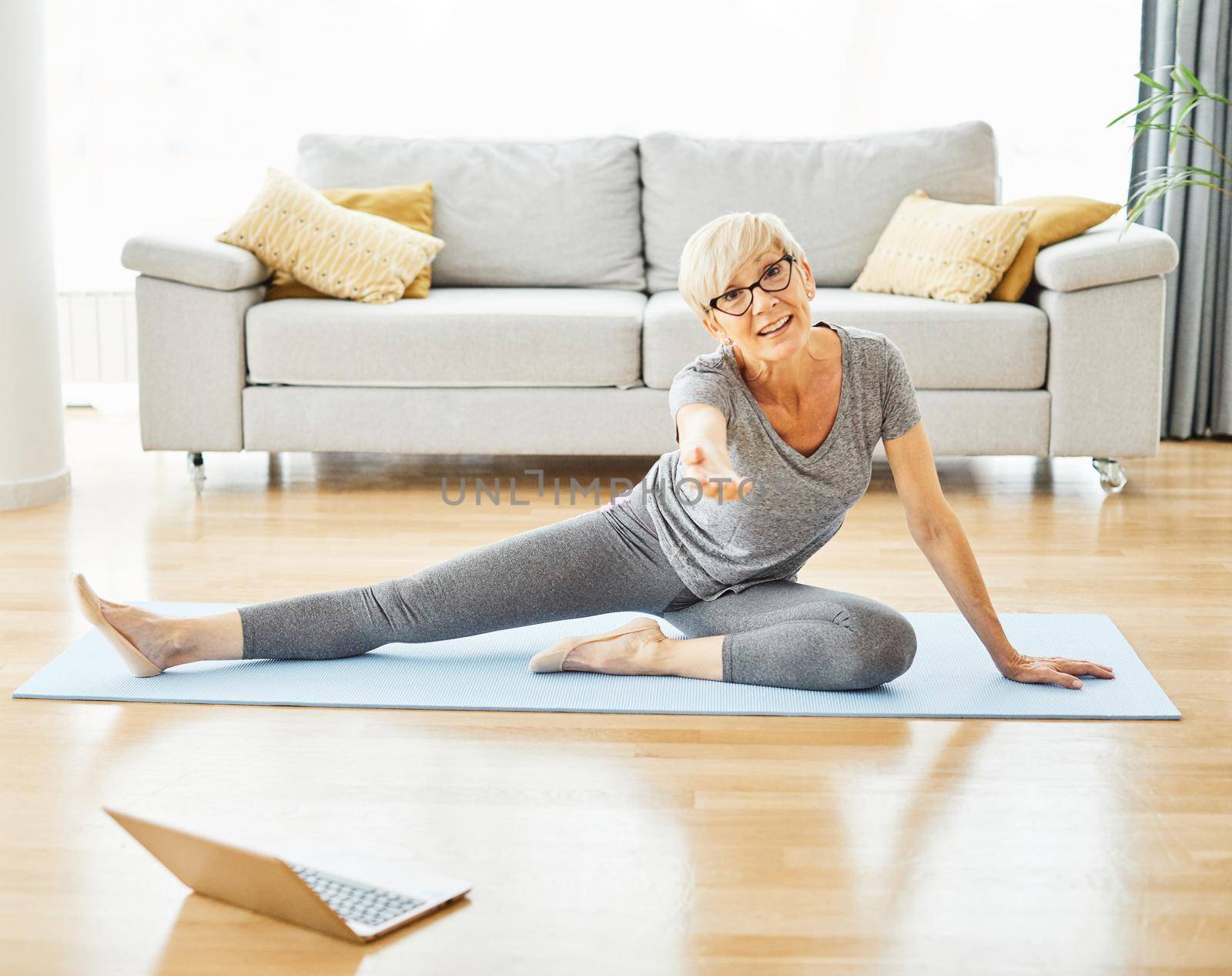 Senior woman exercise using laptop online instructions at home health care