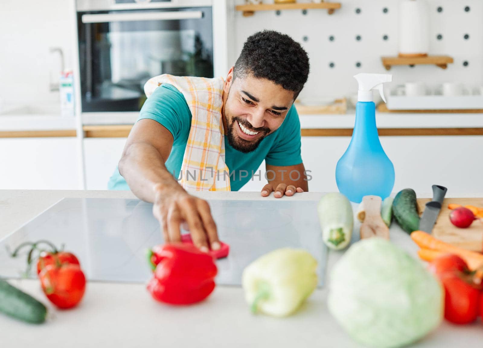 Portrait of a young happy black man cleaning kitchen