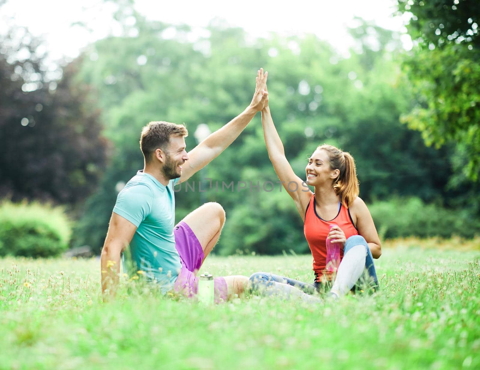 Portrait of a young couple exercising in a park outdoors