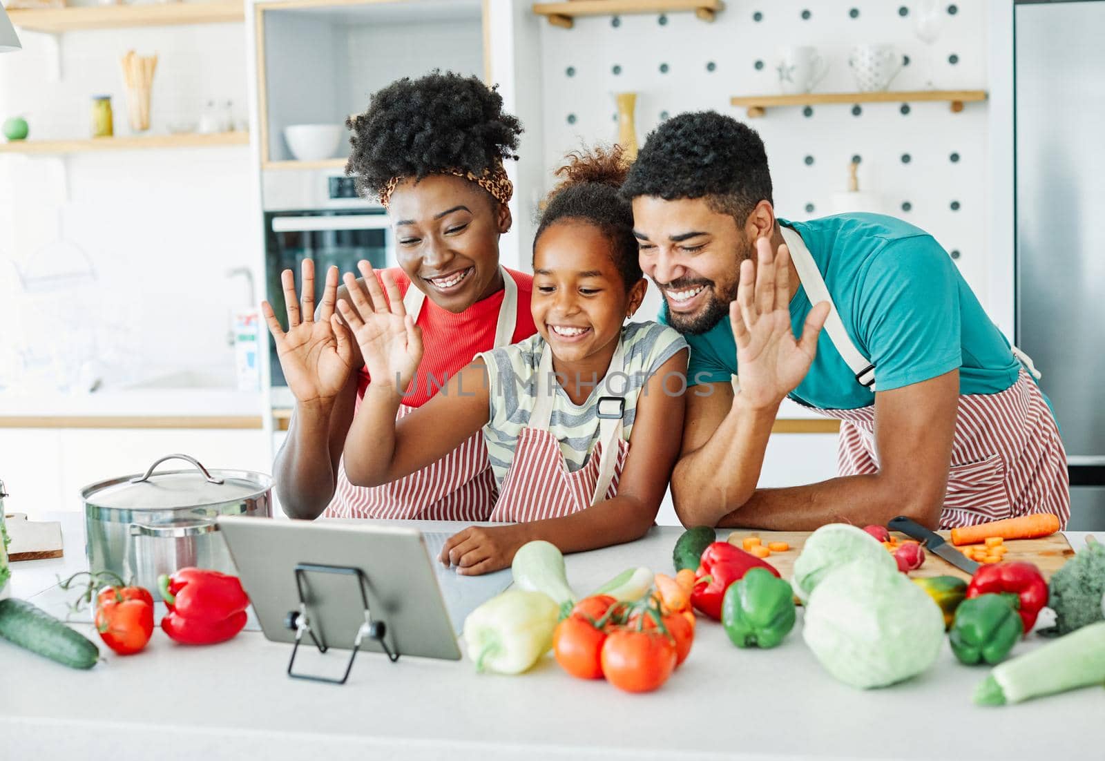 family child kitchen food daughter mother father cooking preparing tablet video call waving happy together by Picsfive